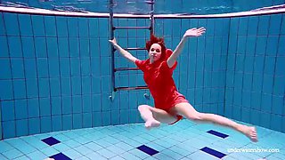 Pretty girl in red sexy open dress swimming