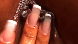 Oiled ebony babe masturbates with her fingers and toy in a close up video