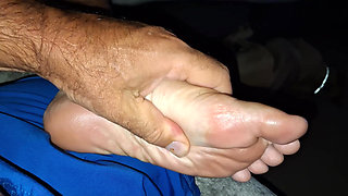 Giving her  a soft foot rub and massage on the couch