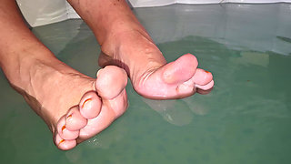 She teases me with her bare feet while splashing in the Hot tub