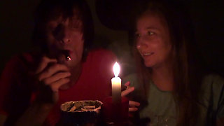 Couple smoke next to candle