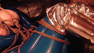 Bondage process: latex mistress and rubber submissive with gag and wet pussy