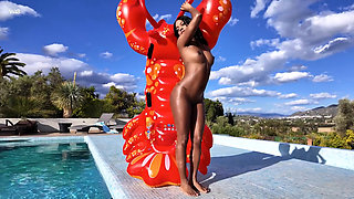 Bubble butt ebony stunner poses nude with a pool float