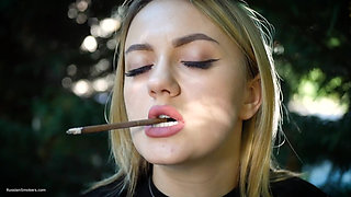 Hot Blonde Babe Smoking Two Black Cigarettes in Nature