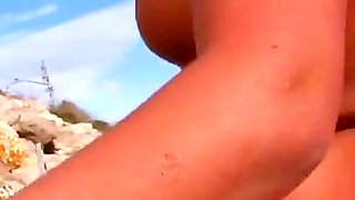 A slut with two soft breasts and blonde hair is ready for some ass fucking on the beach