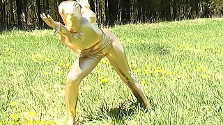 Sexy ebony babe in skintight golden spandex catsuit posing outdoor