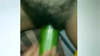 A Young Woman Is Inserting a Cucumber Into Her Pussy